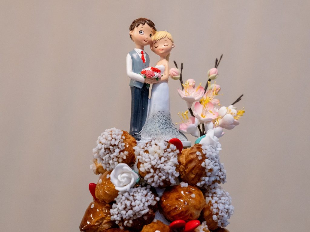 Pièce montée de mariage artisanale avec choux garnis de crème pâtissière vanille et caramel, décorée de fleurs, personnalisable pour les mariés, atelier ou commande boutique Boom Cake à Rumilly, Annecy et Aix-les-Bains