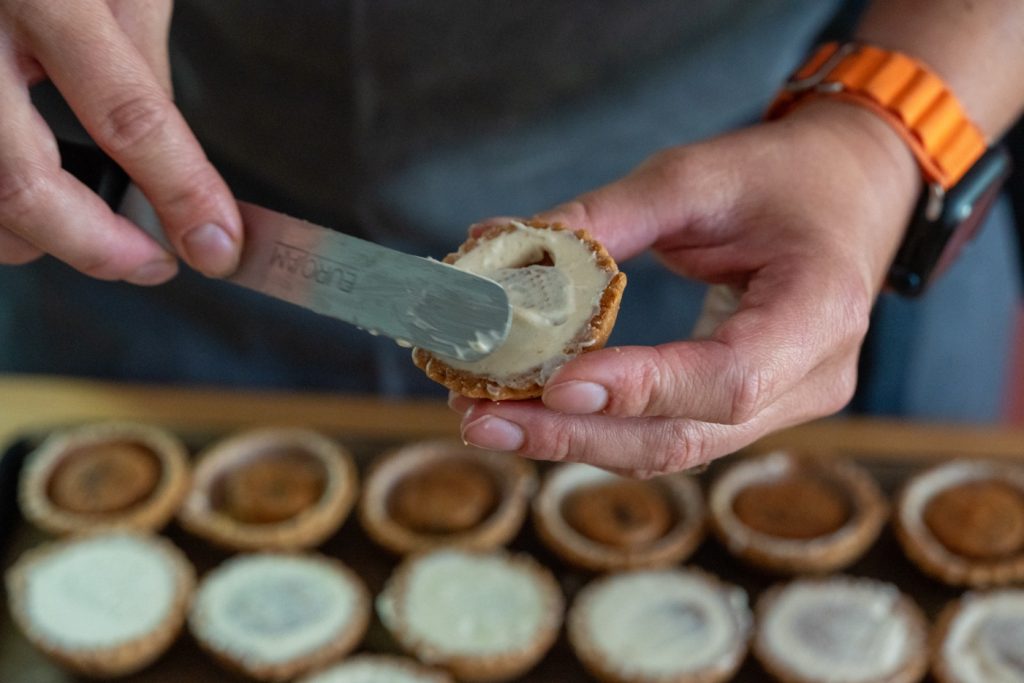 Pâtisserie en cours de montage chez Boom Cake à Rumilly, artisan pâtissier préparant une création gourmande