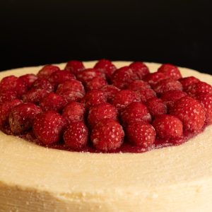 Framboisier artisanal – décor en coque chocolat blanc et framboise au centre sur coulis de framboise